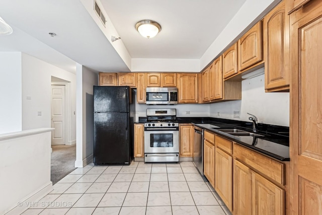 kitchen with visible vents, light tile patterned floors, brown cabinets, appliances with stainless steel finishes, and a sink