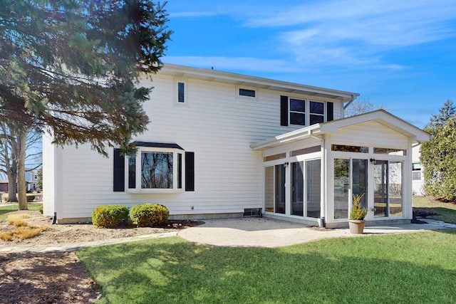 back of property with a patio area, a lawn, and a sunroom