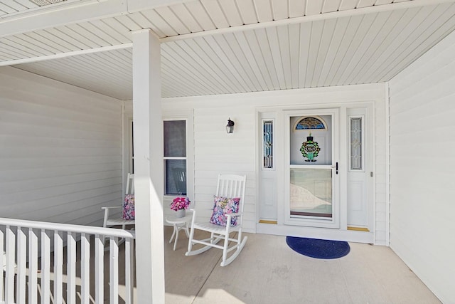 view of exterior entry featuring covered porch