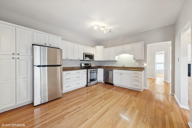 kitchen with sink, light hardwood / wood-style flooring, stainless steel appliances, and white cabinets