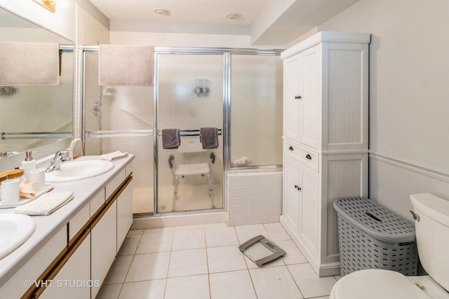 bathroom featuring vanity, tile patterned floors, a shower with door, and toilet