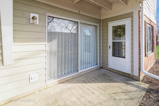 view of exterior entry with a patio area