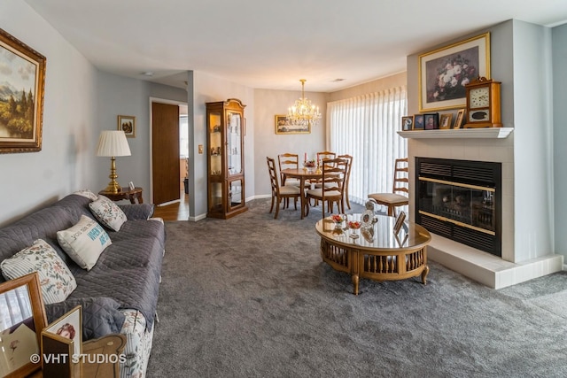 living room featuring an inviting chandelier, a fireplace, and dark colored carpet