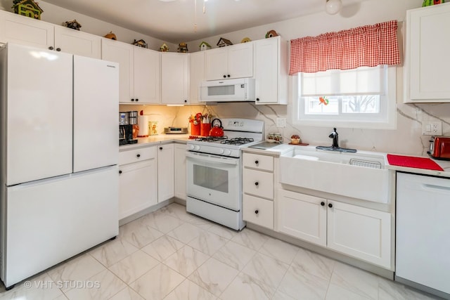 kitchen featuring white cabinetry, sink, white appliances, and decorative backsplash