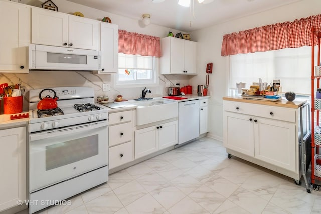 kitchen with ceiling fan, white appliances, sink, and white cabinets