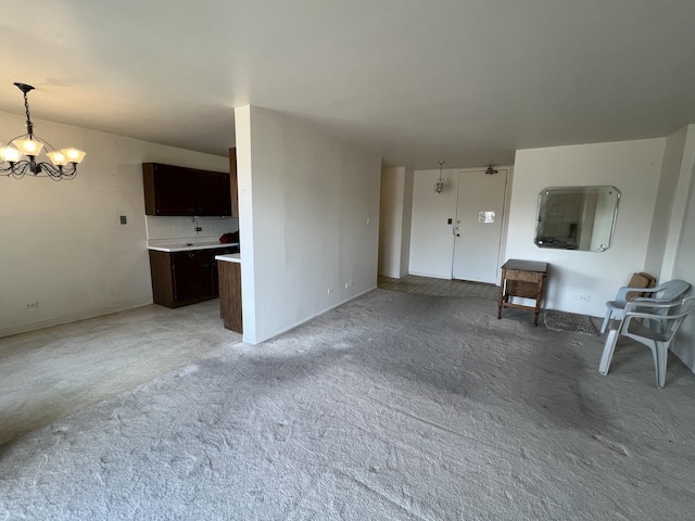 unfurnished living room featuring an inviting chandelier and carpet