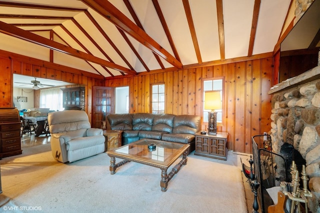 carpeted living room featuring wooden walls, a fireplace, high vaulted ceiling, and beam ceiling