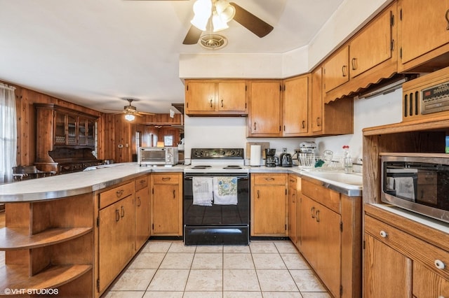 kitchen featuring light tile patterned flooring, electric range, ceiling fan, and kitchen peninsula