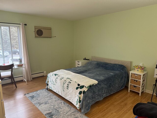 bedroom featuring light wood-type flooring and baseboard heating