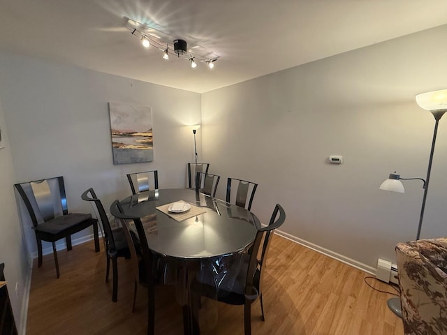 dining space featuring a baseboard radiator and light hardwood / wood-style flooring