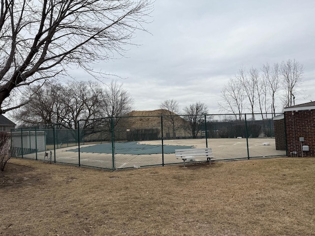 view of tennis court featuring a lawn