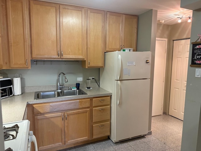 kitchen with sink, light brown cabinets, and white appliances