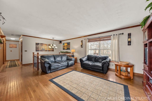 living room with ornamental molding, wood-type flooring, and a notable chandelier