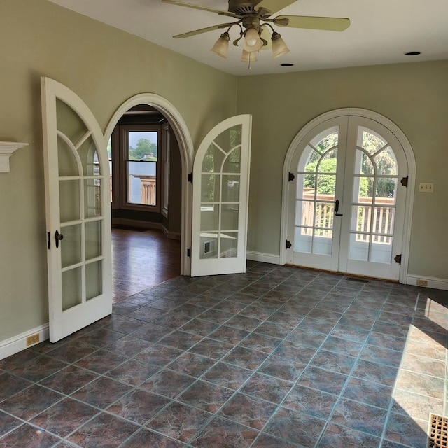 empty room featuring ceiling fan and french doors