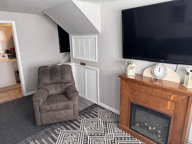 living area with tile patterned flooring, washer / dryer, and vaulted ceiling