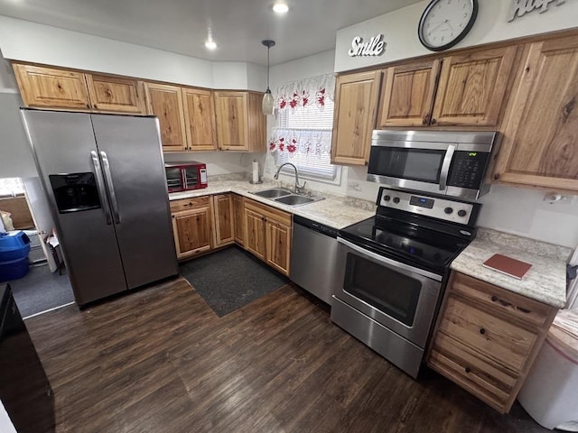 kitchen featuring hanging light fixtures, appliances with stainless steel finishes, sink, and dark hardwood / wood-style flooring