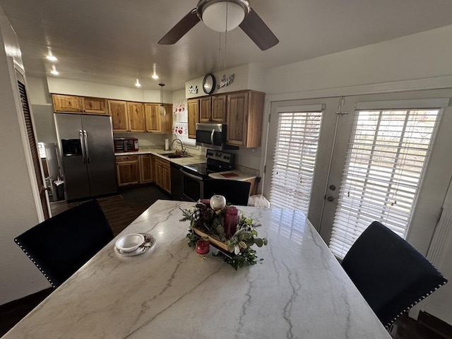 kitchen featuring sink, ceiling fan, appliances with stainless steel finishes, light stone countertops, and french doors