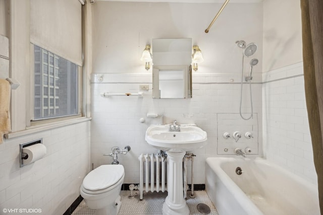 full bathroom with sink, tile walls, tile patterned floors, toilet, and tiled shower / bath