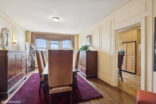 dining area with crown molding and dark wood-type flooring