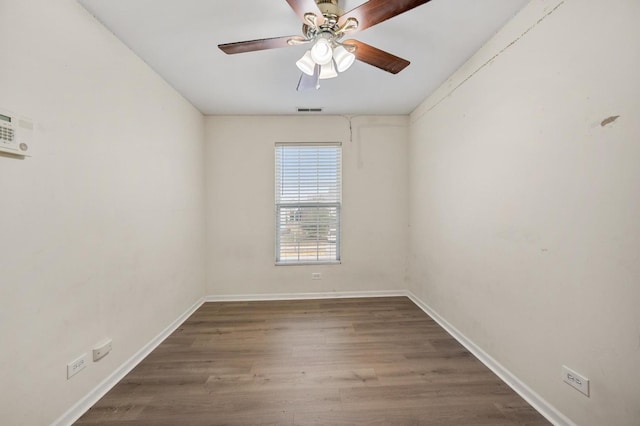 empty room with ceiling fan and dark hardwood / wood-style flooring