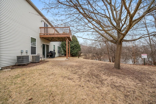 view of yard featuring cooling unit, a wooden deck, and a patio