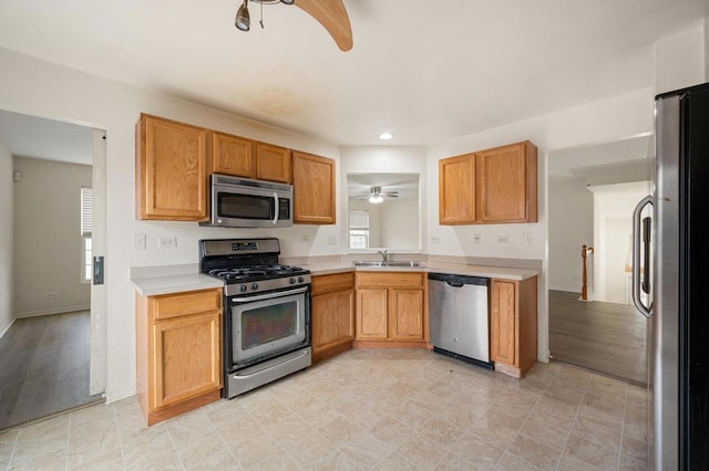 kitchen featuring appliances with stainless steel finishes, sink, and ceiling fan