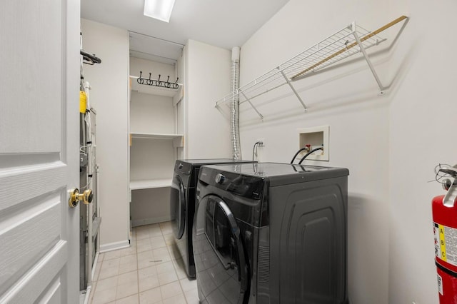 clothes washing area featuring washing machine and dryer and light tile patterned floors