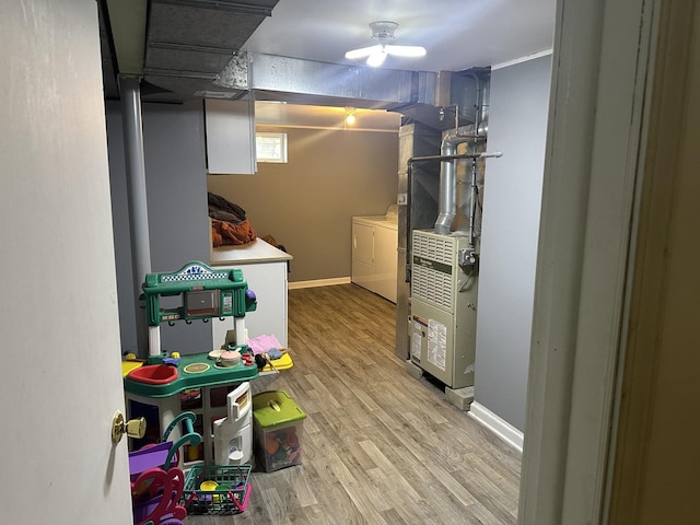 basement featuring light hardwood / wood-style floors and washing machine and dryer