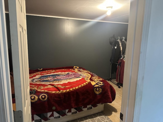 tiled bedroom featuring ornamental molding