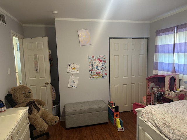 bedroom with a closet, ornamental molding, and dark hardwood / wood-style floors