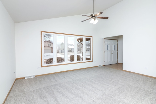 empty room with high vaulted ceiling, light colored carpet, and ceiling fan