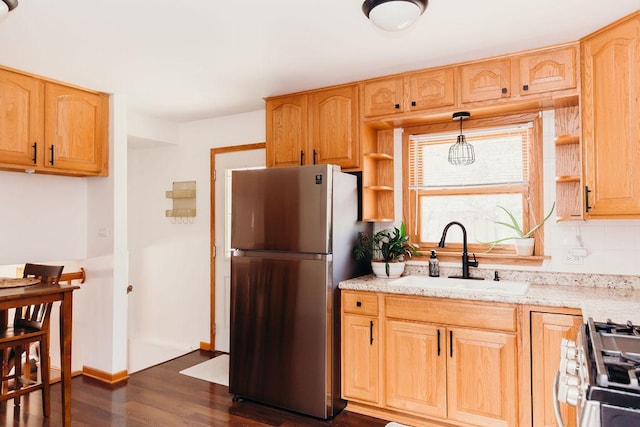 kitchen featuring dark hardwood / wood-style floors, tasteful backsplash, sink, hanging light fixtures, and stainless steel appliances