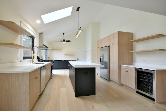 kitchen with stainless steel appliances, wine cooler, a kitchen island, decorative light fixtures, and wall chimney exhaust hood