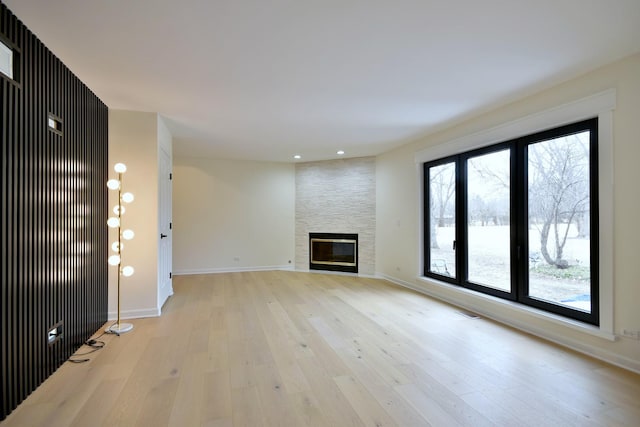 unfurnished living room with a fireplace and light hardwood / wood-style floors