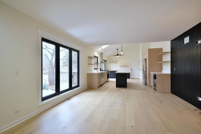 kitchen featuring pendant lighting, stainless steel fridge, a kitchen island, and light hardwood / wood-style flooring