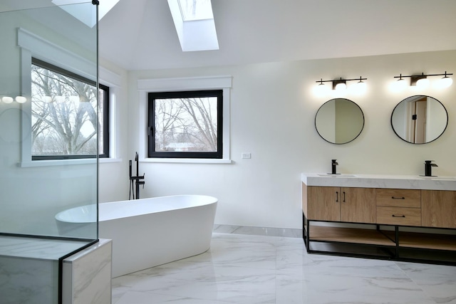 bathroom with vanity, a skylight, and a bathtub