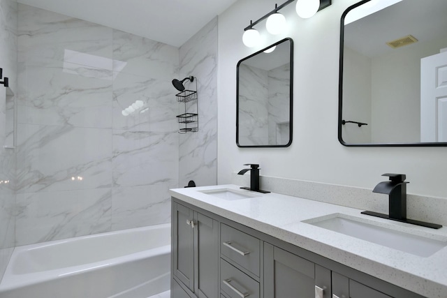 bathroom featuring vanity and tiled shower / bath