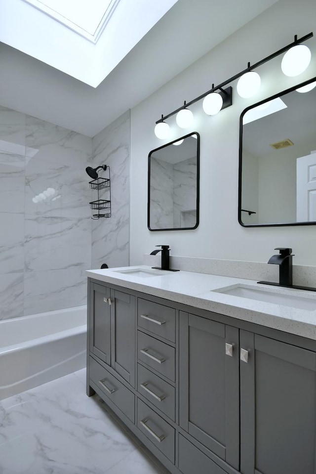 bathroom featuring vanity, tiled shower / bath combo, and a skylight