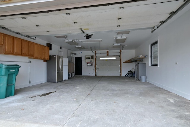 garage with stainless steel refrigerator and a garage door opener