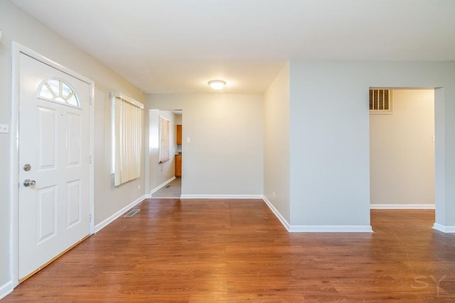 foyer with visible vents, baseboards, and wood finished floors