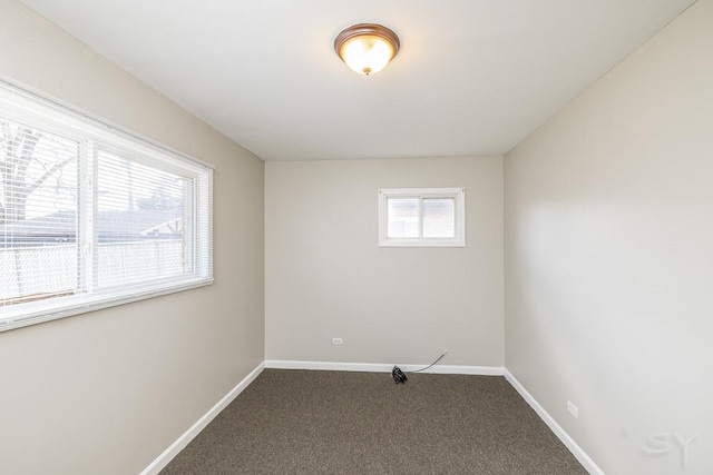 spare room featuring carpet floors and baseboards