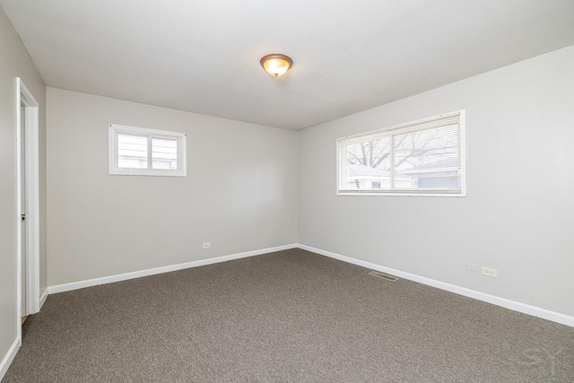 unfurnished room featuring carpet, visible vents, and baseboards