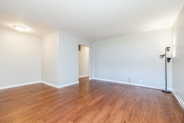 spare room with wood finished floors and baseboards