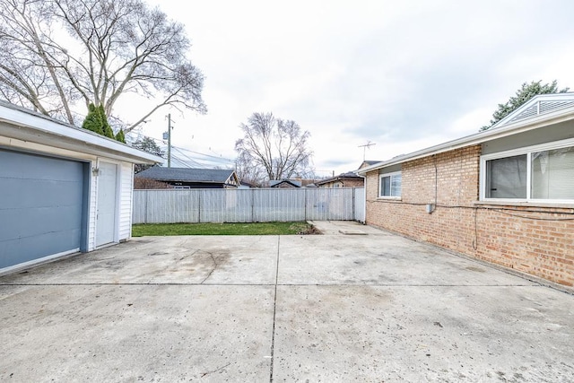 view of patio / terrace with a garage, concrete driveway, and a fenced backyard