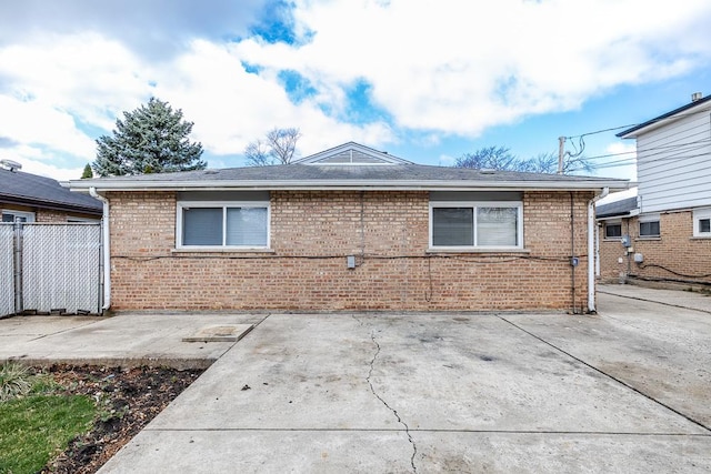 exterior space with brick siding, a patio, and fence