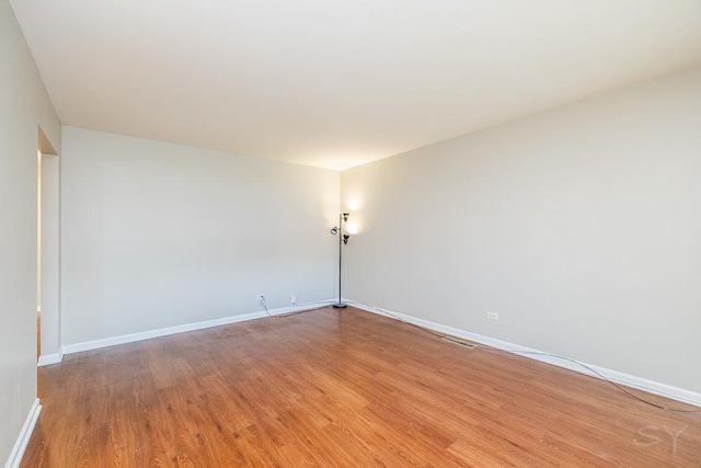 unfurnished room with light wood-style flooring and baseboards