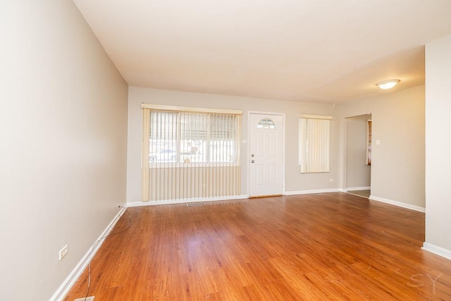 empty room with visible vents, baseboards, and wood finished floors