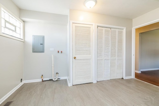 washroom with visible vents, light wood-style flooring, laundry area, electric panel, and baseboards