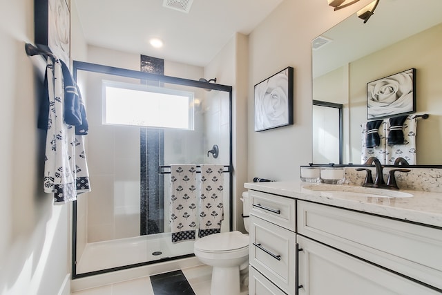 bathroom featuring vanity, a shower with shower door, and toilet