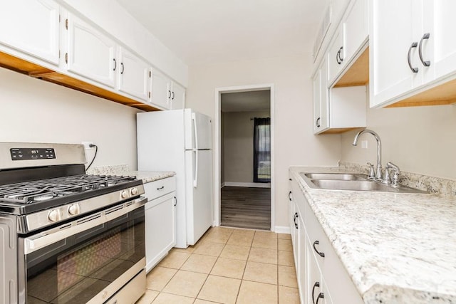 kitchen with stainless steel gas range, light countertops, and white cabinetry